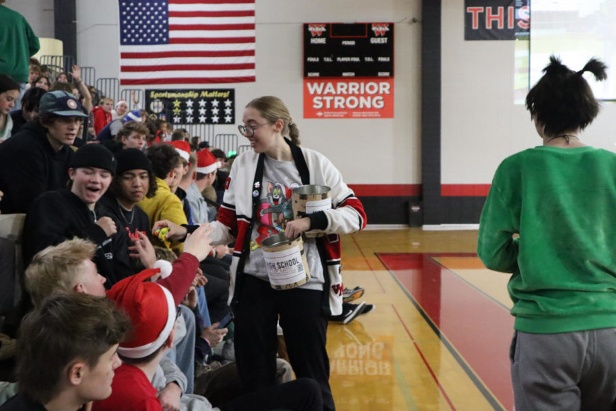 Raegan Rodgers, SBO, collects money and hands out rubber ducks to students during the assembly. Activities included a dance-off, mystery auction and sundae drop. 